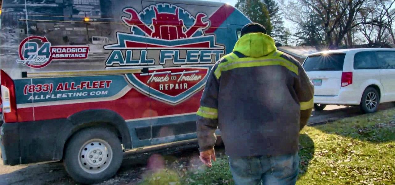 All Fleet Inc technician in a high-visibility jacket at a branded All Fleet Inc service van